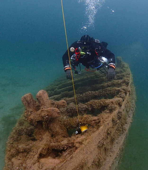 DAF hangs in sidemount scuba gear, with
left tank in slightly poor trim, over a small submerged wreck